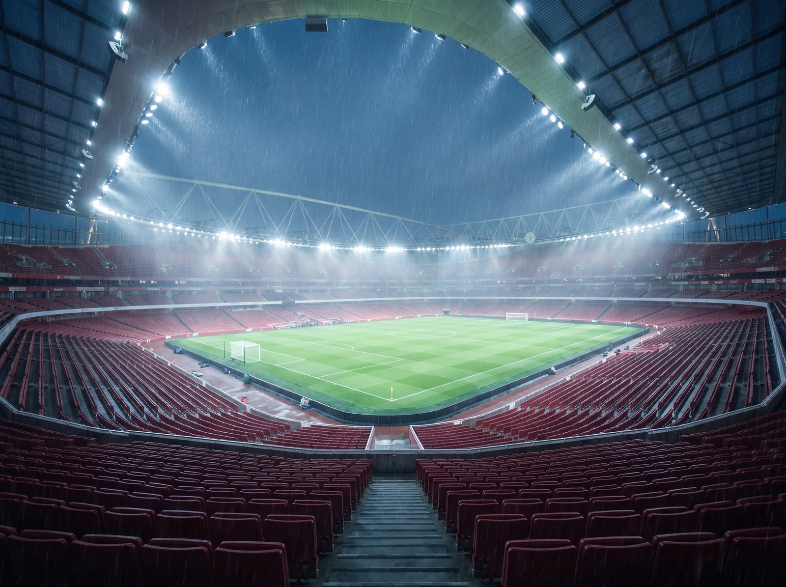 A high wide view of a floodlit stadium at night from the empty stands